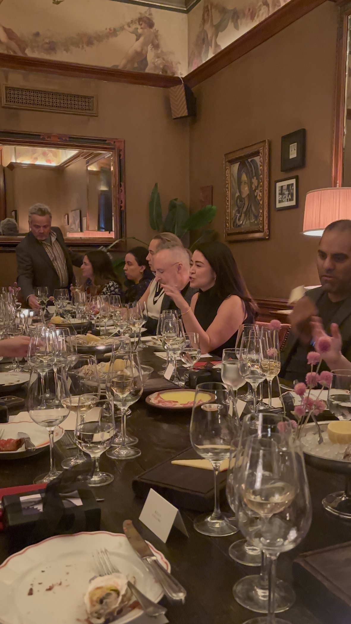 Guests in conversation around a candlelit Future Commerce salon dinner table